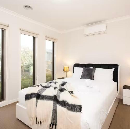 a white bedroom with a black and white bed at hayes getaway in Rosebud