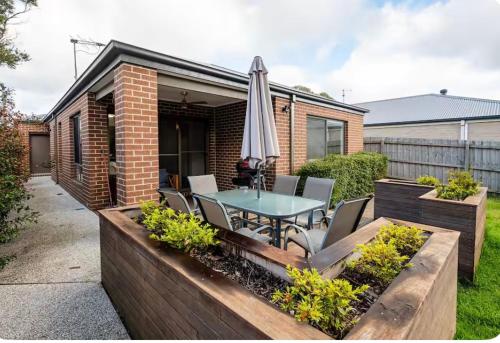 a patio with a table and an umbrella at hayes getaway in Rosebud