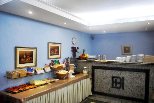 サンパウロにあるHotel Brigadeiroの食べ物が展示されているレストランのビュッフェライン