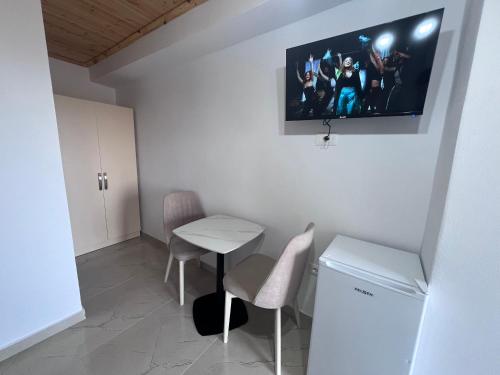 a small room with a table and a tv on the wall at Hotel I Pari in Shkodër