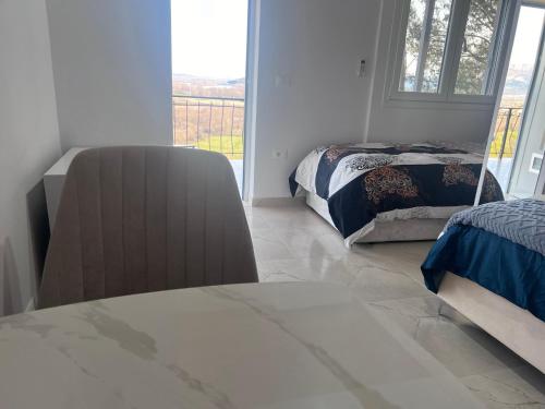 a living room with two beds and a window at Hotel I Pari in Shkodër