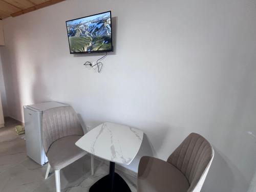 a room with a table and chairs and a tv on the wall at Hotel I Pari in Shkodër