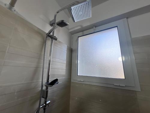 a bathroom with a shower with a large window at Hotel I Pari in Shkodër