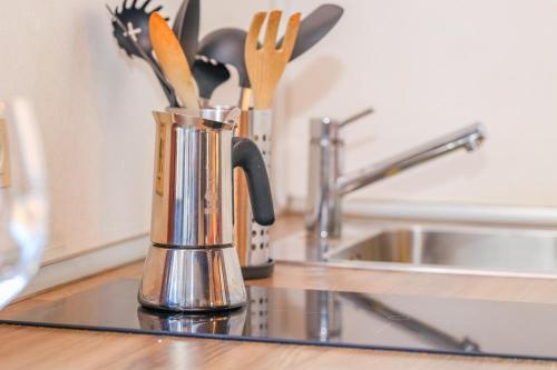 パドヴァにあるDimora Collegio San Marcoの- シンクの横にコーヒーマグカップ付きのキッチンカウンター