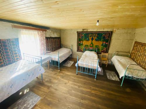 a room with three beds and a painting on the wall at Mate's Space in Akhmety
