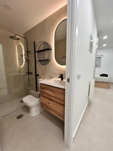 Un baño con inodoro, lavabo y espejo. en AeroSuites102 Alojamiento Madrid, en Madrid