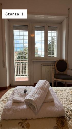 a bed with towels on it in a room with windows at Sweet Rome Ipogeo Degli Ottavi in Rome