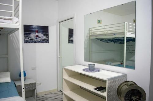 a white bedroom with a mirror and a bed at BluBed Mare - Quadrupla Bagno Cucina e Balcone in San Giovanni Teatino