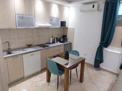 a small kitchen with a wooden table and chairs at Apartments Nancy in Kotor