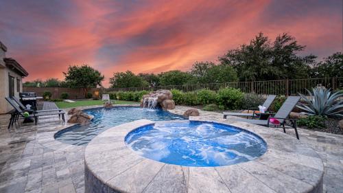 ein Hinterhof mit einem Pool mit Wasserfall und einem Wasserspiel in der Unterkunft Desert Queen Queen Creek in Queen Creek