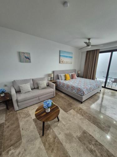 a living room with a couch and a bed at Tu estancia perfecta - ubicación y privacidad in Playa del Carmen