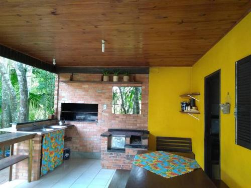 a kitchen with a brick fireplace and a stove at Sítio em Nova Veneza - Caminho dos Pinheiros in Siderópolis