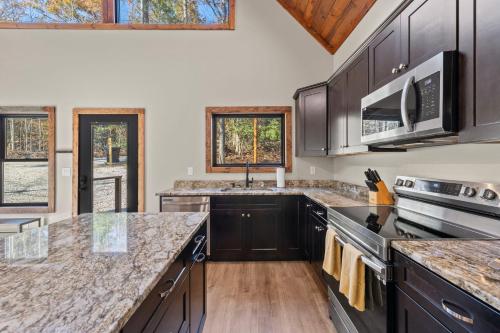 a kitchen with black cabinets and a counter top at Anchor Point in Rogers