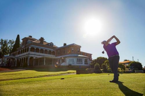 a woman is standing in front of a mansion at Paddington Villa 2 - wi-fi, Netflix in Orange