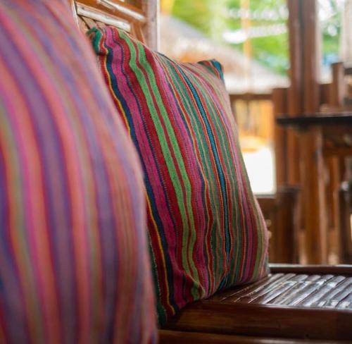 a colorful striped pillow sitting on a wooden bench at Cabang Campsite - Private Island Experience in San Vicente