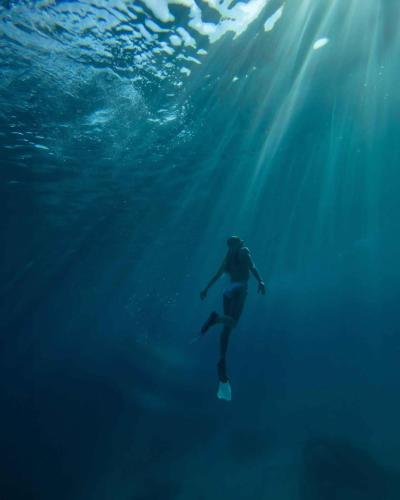 a person is swimming in the ocean under the water at Cabang Campsite - Private Island Experience in San Vicente