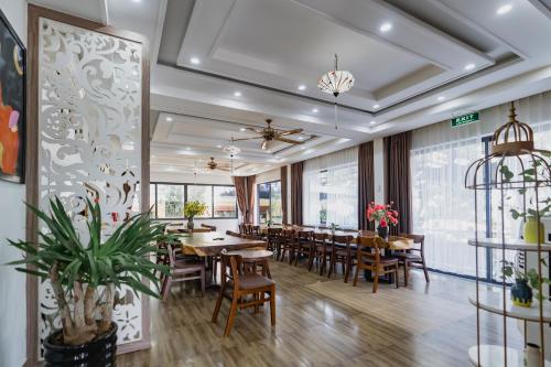 a dining room with wooden tables and chairs at 1 Stop ViVi An Bang Beach Hoi An Hotel in Hoi An