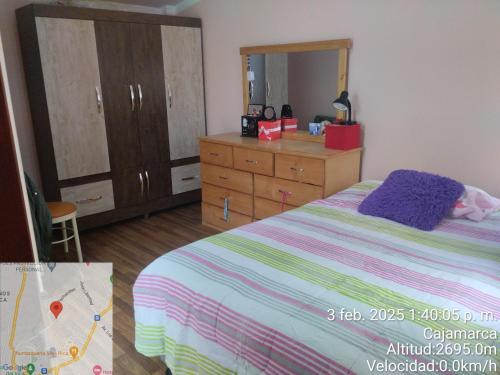 a bedroom with a bed and a dresser and a mirror at Departamento el Mirador Concax in Los Baños del Inca