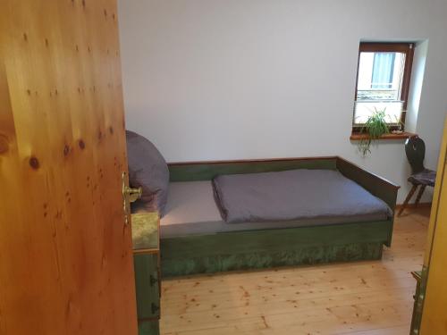 a small bed in a room with a window at Haus Bachrauschen in Kirchanschöring