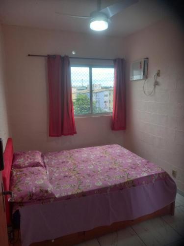 a bedroom with a bed with pink sheets and a window at Pousada Victor - Arte in Manaus