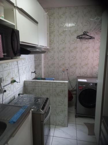 a small kitchen with a stove and a dishwasher at Pousada Victor - Arte in Manaus