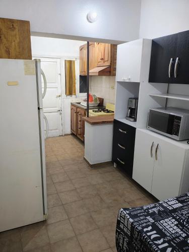 a kitchen with white cabinets and a white refrigerator at La Clavelina in Potrerillos