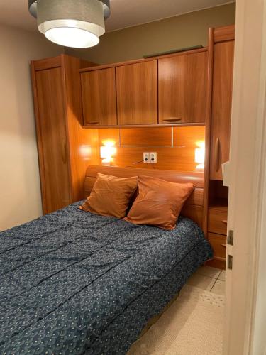 une chambre avec un lit avec une tête de lit en bois dans l'établissement Domaine des quatre terres, à Lesparre-Médoc