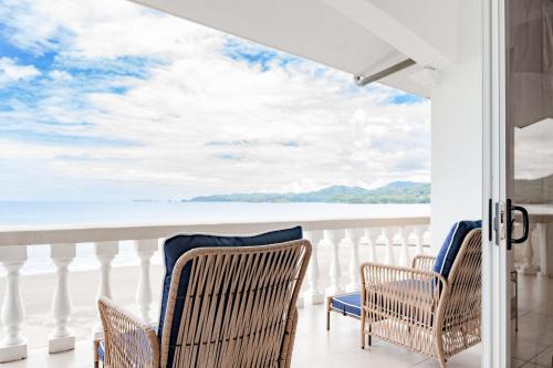 two chairs on a balcony with a view of the ocean at Sunset 303 - Ocean View 3 Br Condo in Tempate