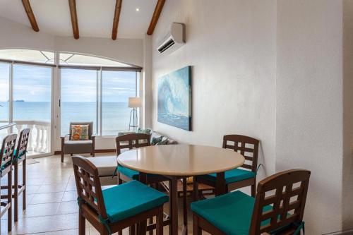 a dining room with a table and chairs and the ocean at Sunset 303 - Ocean View 3 Br Condo in Tempate