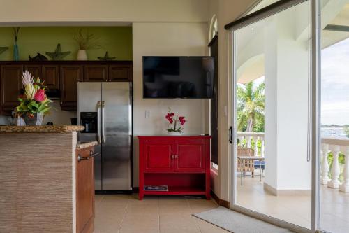 a kitchen with a red cabinet and a refrigerator at Sunset 303 - Ocean View 3 Br Condo in Tempate