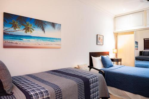 a bedroom with two beds and a painting on the wall at Sunrise 12- 2 Bedroom Penthouse in Tamarindo