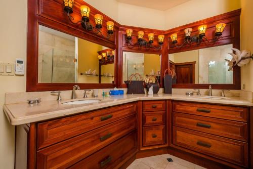 une salle de bain avec deux lavabos et deux miroirs dans l'établissement Palms 23 Luxury Beachfront Villa, à Playa Flamingo