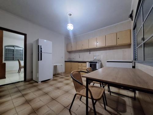 a kitchen with a table and chairs and a refrigerator at CASA - 3 quartos com ar - garagem para 3 carros in Campo Grande
