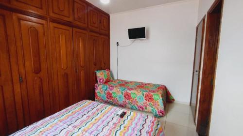 a small bedroom with a bed and a chair at CASA - 3 quartos com ar - garagem para 3 carros in Campo Grande