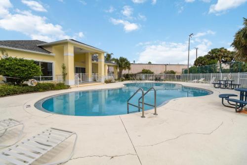 a large swimming pool with chairs and tables at Huge Screened Patio That Overlooks Lake Buck, Near Famous Attractions!! in Orlando