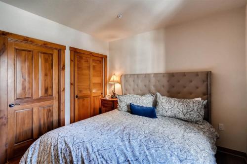 布雷肯里奇1 Bedroom Mountain Condo Located In Historic Downtown Breckenridge Near Shopping, Dining, And Restaurants的卧室里有一张大床，配有蓝色枕头