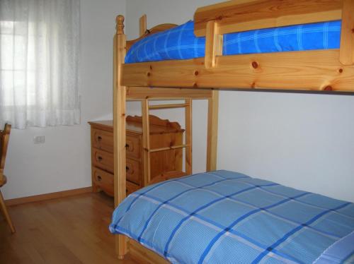 a bedroom with a bunk bed and a dresser at Appartamento Zorzi in Ziano di Fiemme
