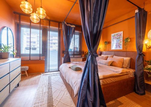 a bedroom with a bed with curtains in it at Heart of the City - Free Parking in Pristina