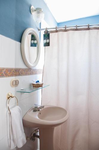 a bathroom with a sink and a shower curtain at Hotel La Posada del Angel in San Salvador