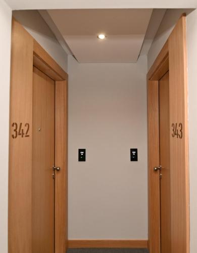 two wooden doors in a room with white walls at Apartman D343 Aparthotel Vucko Jahorina privat apartman in Jahorina