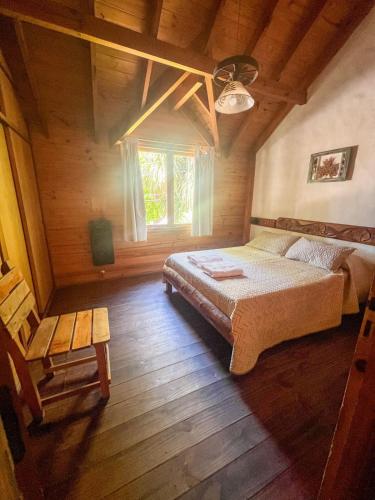 a bedroom with a large bed and a window at Cabañas Arique in San Martín de los Andes