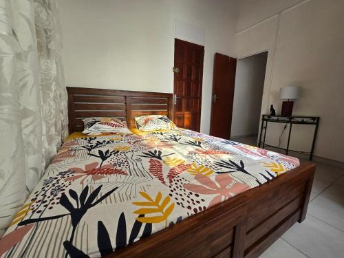 a bedroom with a bed with a colorful comforter at Appartement cosy et lumineux in Les Abymes