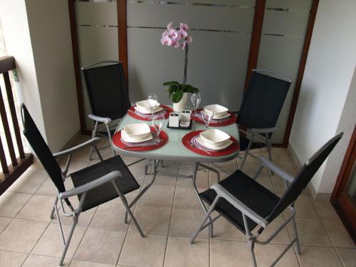 a dining room table with four chairs and a table with a flower at Apartament 43 "Zachodni" - Pod Aniołem in Kazimierz Dolny