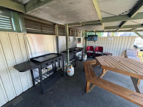 a patio with a grill and a picnic table at Westshore Holiday Park in Napier