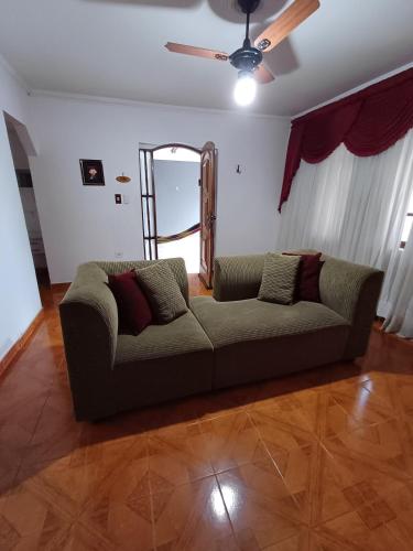 a living room with a couch and a mirror at Casa Master Bauru Com Ar Condicionado e Piscina in Bauru
