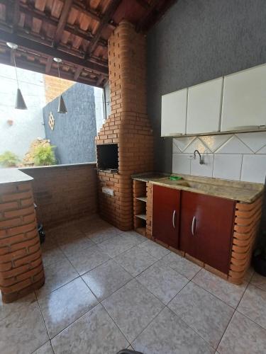 a kitchen with a counter and a brick wall at Casa Master Bauru Com Ar Condicionado e Piscina in Bauru