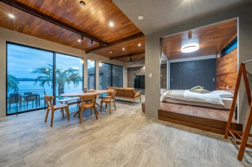 a bedroom and dining room with a bed and a table at Wat resort シーフロント奥能登 in Anamizu