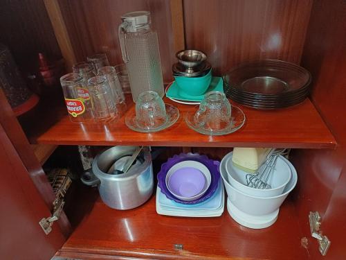 a wooden shelf with bowls and plates and a blender at Casa Master Bauru Com Ar Condicionado e Piscina in Bauru