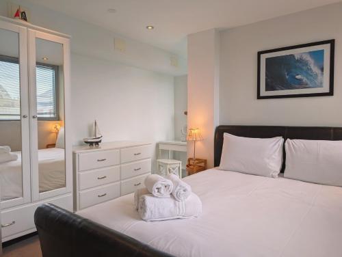a bedroom with a bed with towels on it at Modern Apartment By The Beach in Newquay