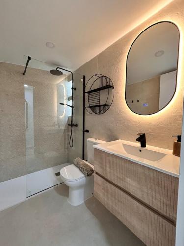 a bathroom with a sink and a toilet and a mirror at AeroSuites201 Alojamiento Madrid in Madrid